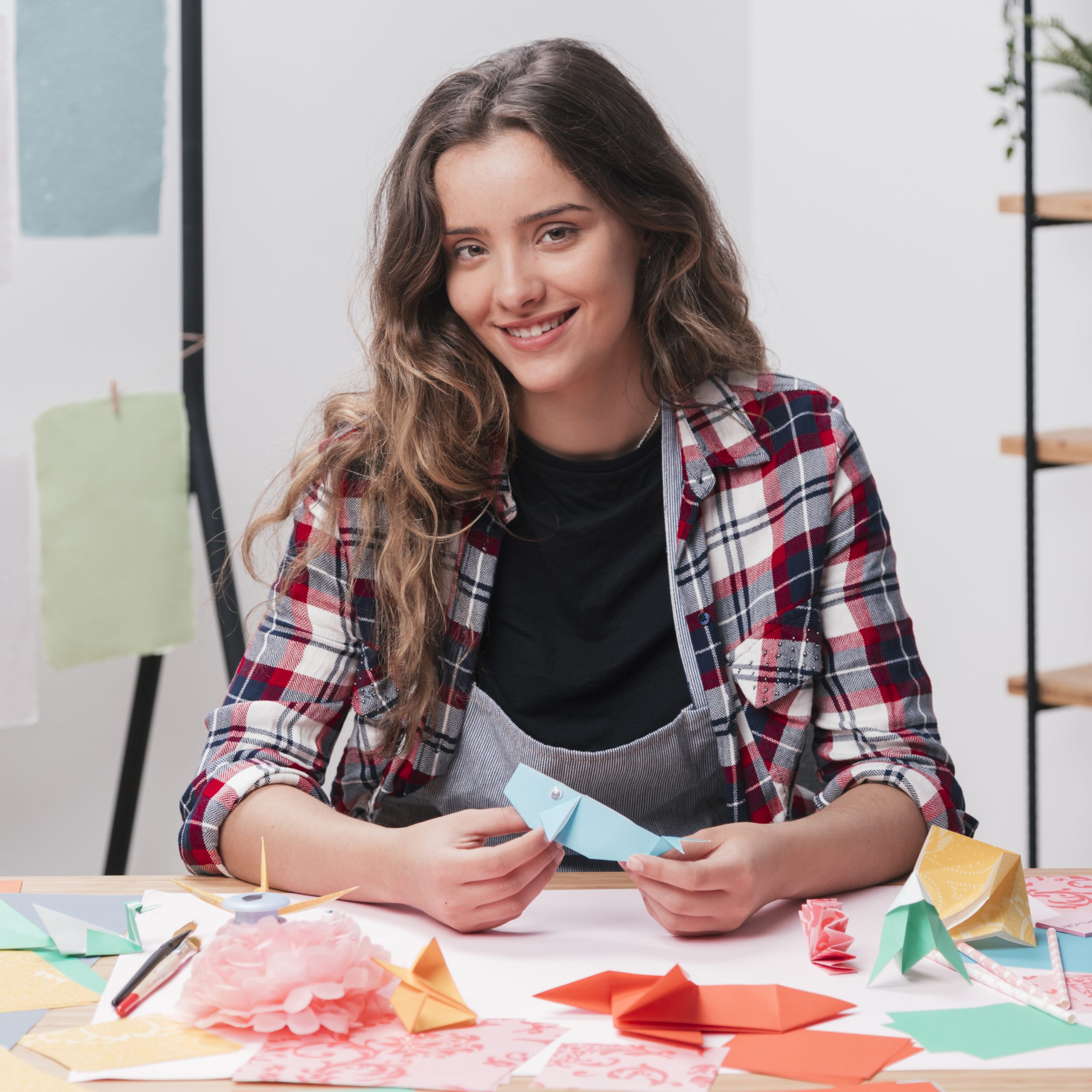 happy-woman-holding-origami-craft-looking-camera