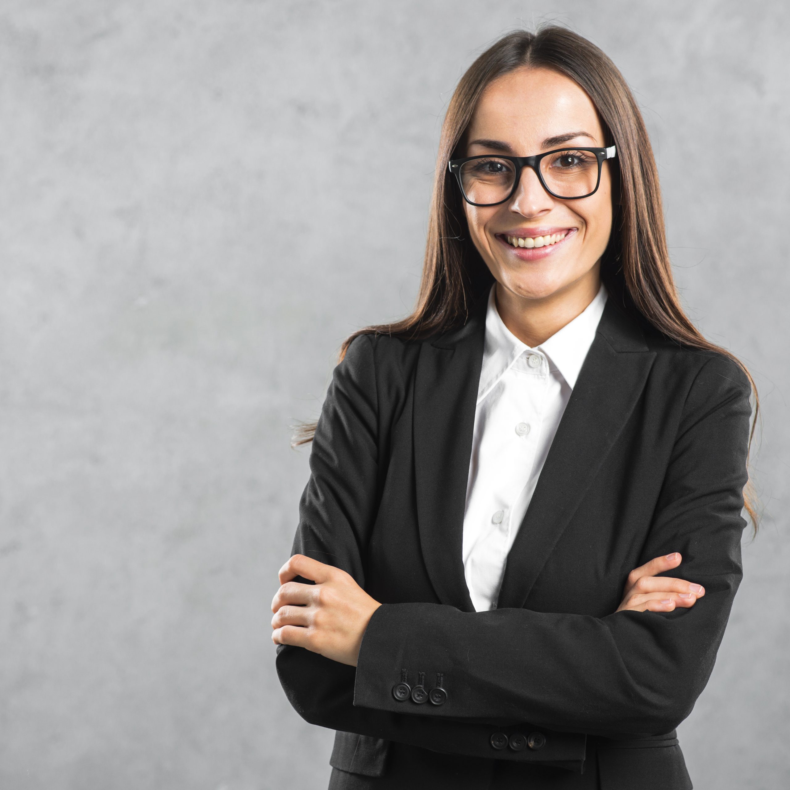 retrato-de-una-empresaria-joven-sonriente-de-pie-con-su-brazo-cruzado-contra-la-pared-gris
